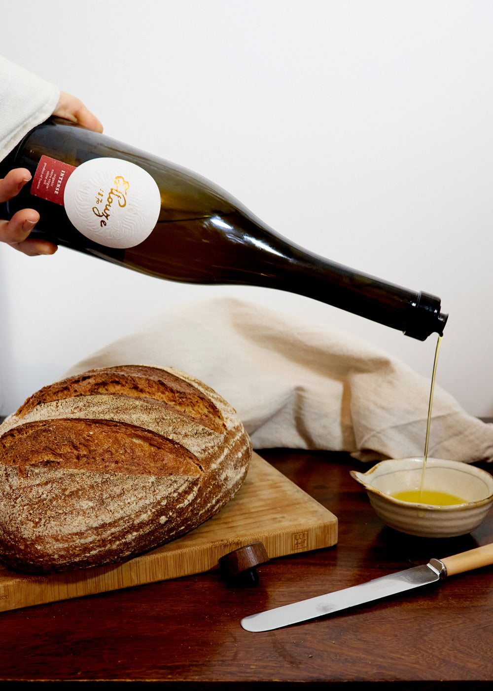 Intense Organic Extra Virgin Olive Oil 500ml served with fresh bread, highlighting its rich flavor and ideal pairing for culinary delights.